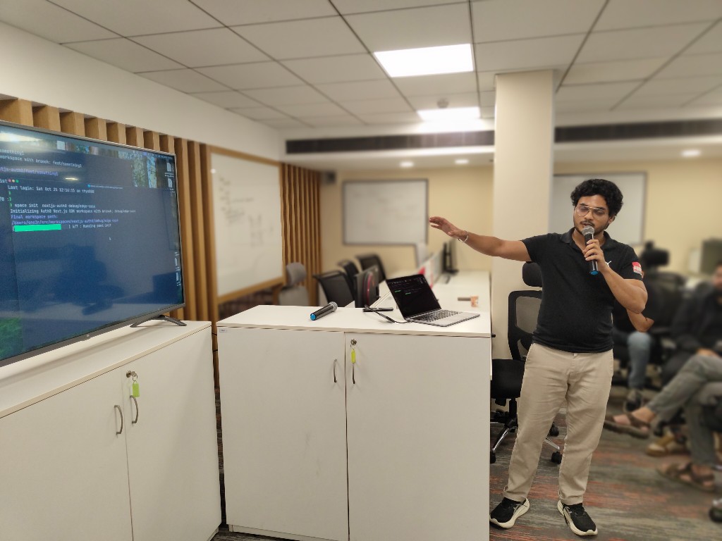 Speaker presenting with terminal output visible on a screen