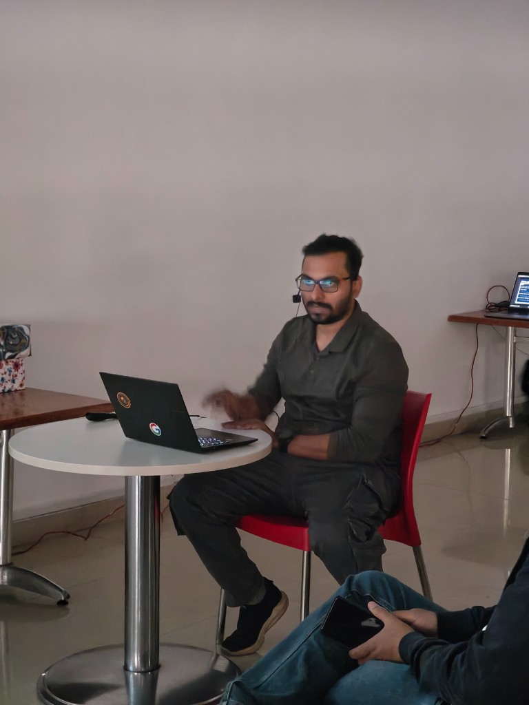 Speaker at table delivering a terminal-focused talk during Episode 3