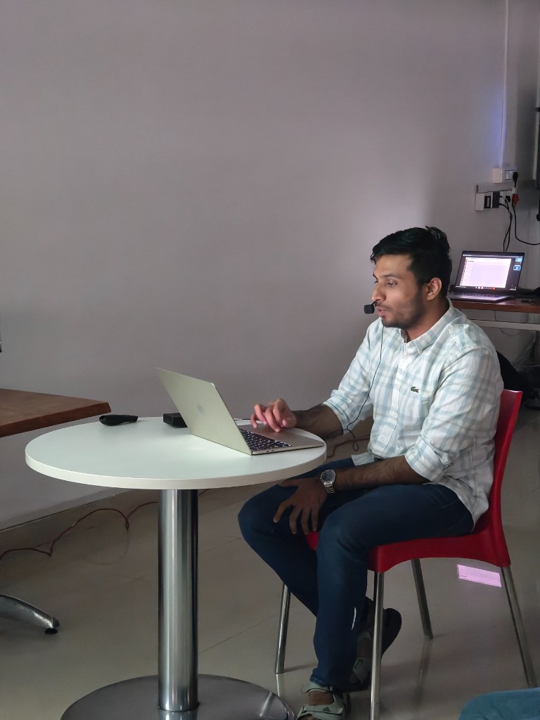 Speaker in white shirt presenting from a laptop at Episode 3